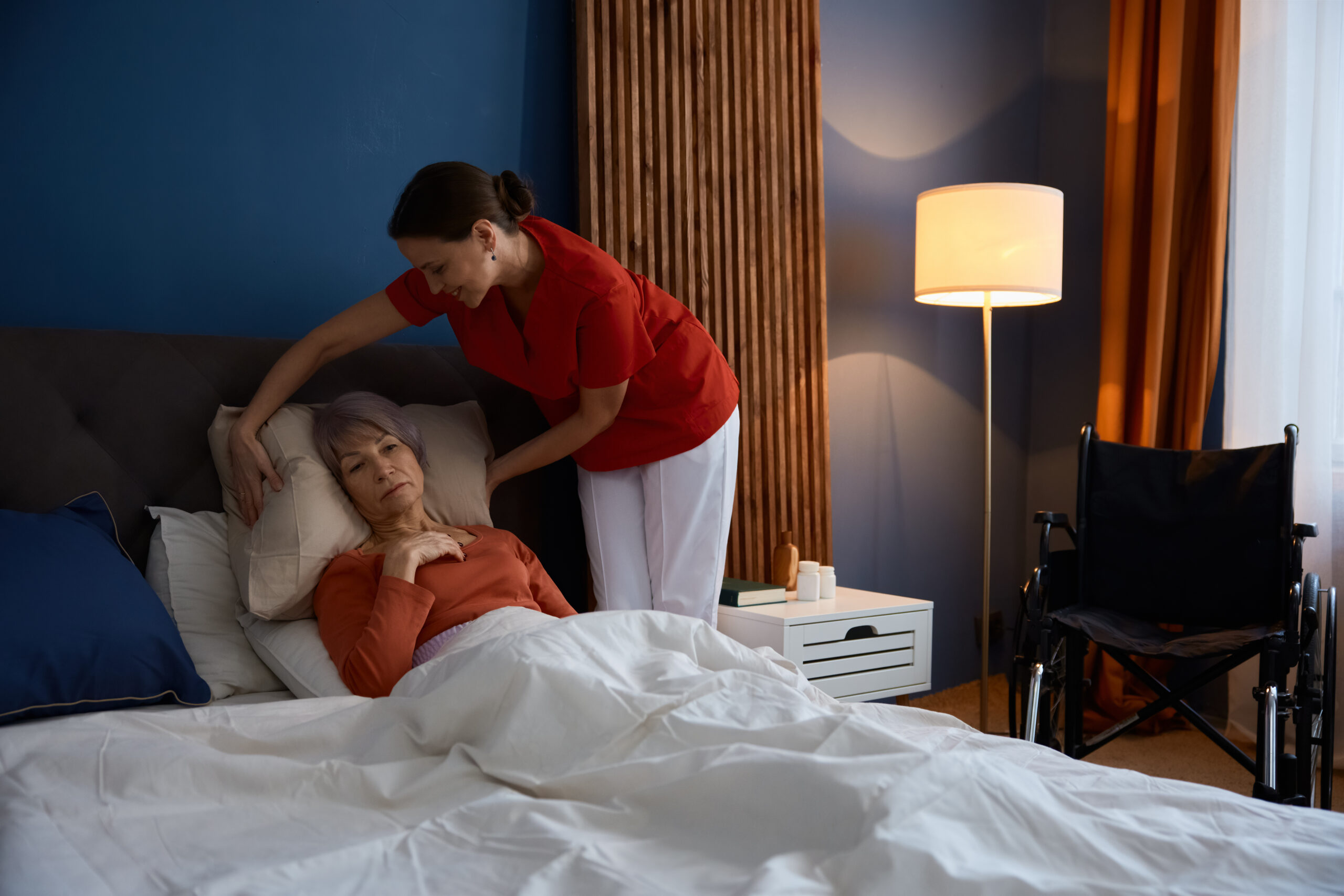 Caregiver helping old woman suffering from Alzheimer disorder providing health care service at home. Nurse caring of elderly female patient with paralysis of limbs or muscles weakness