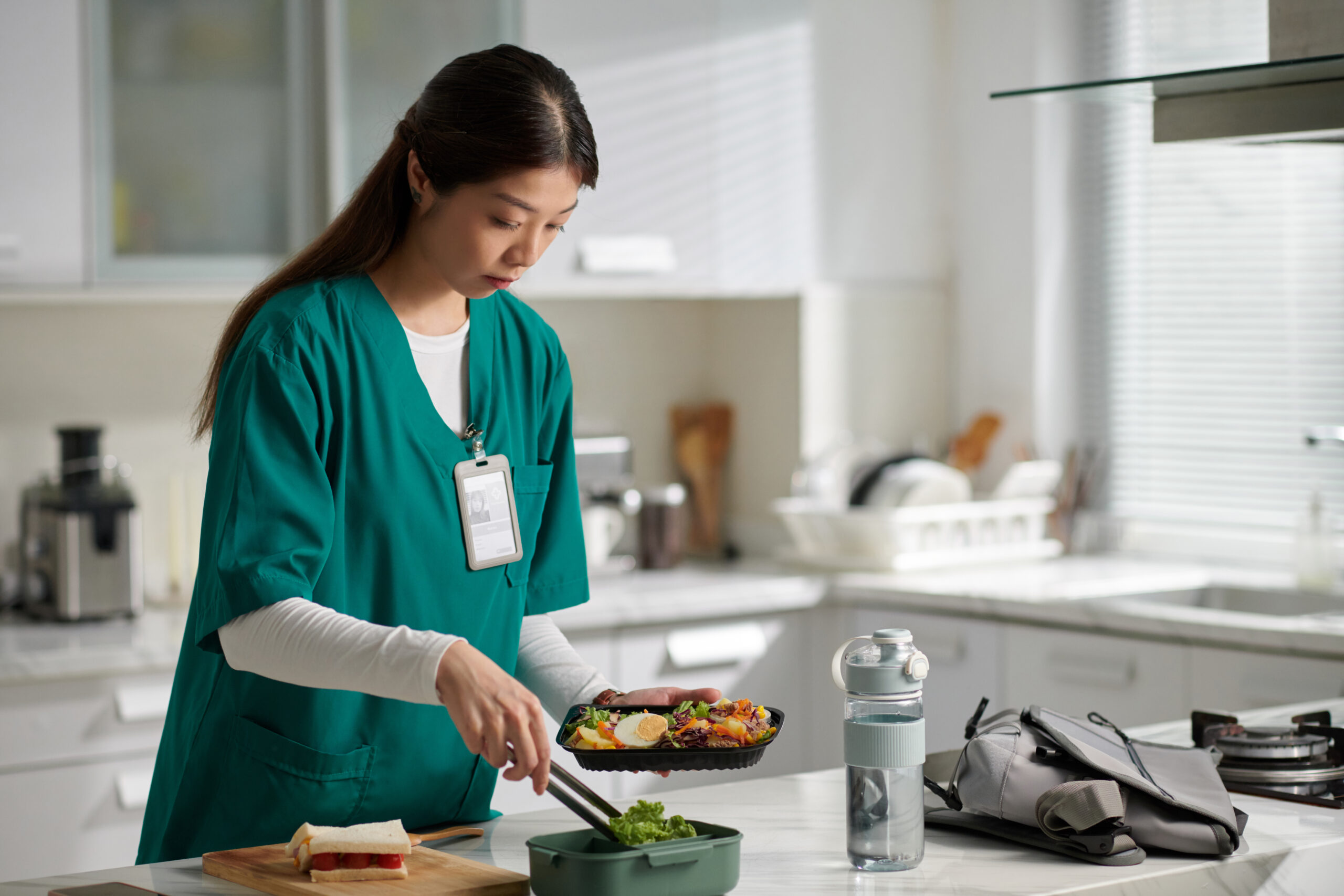 Medical nurse preparing containers with food to have lunch at work
